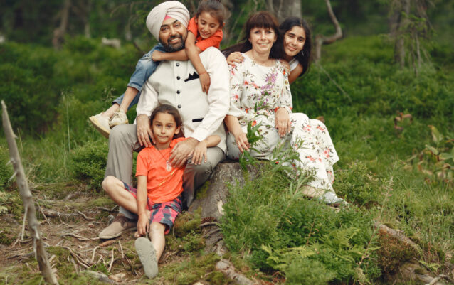 Indian man in a forest. Male in a traditional turban. International family in a summer forest.